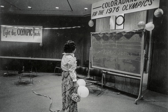  A lone celebrant quietly views tally board at the Denver Olympic Committee victory headquarters.
