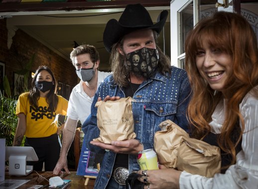 Chewy Tjoe and Will Ewing (rear) give free meals to musicians Ben Mastwyk and Ruby Jones at  Brunswick Ballroom.