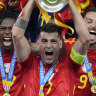 Spain’s Alvaro Morata holds the trophy as he celebrates with his teammates