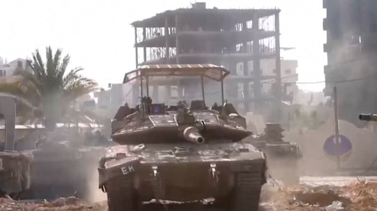 An Israeli tank drives through Gaza City.