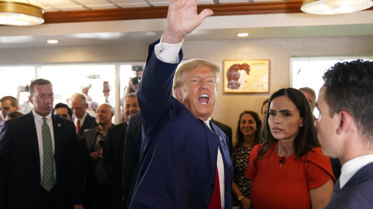 Donald Trump waves to supporters at Versailles restaurant.