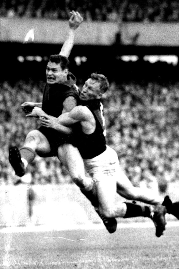 Kicking a goal for Melbourne as Essendon back pocket player Bob Suter tries to smother him in 1957.