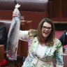 The Greens’ environment spokesperson Sarah Hanson-Young holds up a salmon during Question Time in the Senate.