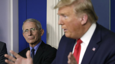 Anthony Fauci, left, listens as President Donald Trump speaks during a Coronavirus Task Force news conference.