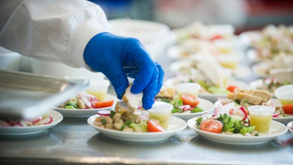 A business class meal is finished off in the cold kitchen (salad with chicken, cherry tomatoes, Cannellini beans and dill vinaigrette). 