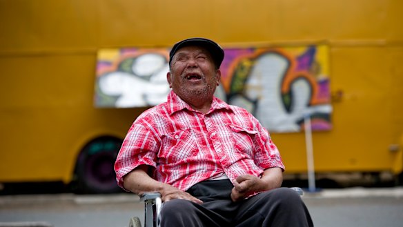 George Thaung, the owner of the Mandalay Bus in Braddon, celebrates the restoration of the bus in 2013.