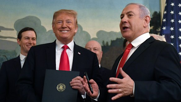Donald Trump smiles as he holds a proclamation formally recognising Israel's sovereignty over the Golan Heights with Israeli Prime Minister Benjamin Netanyahu.