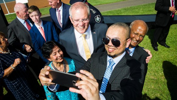 Prime Minister Scott Morrison takes a photo with new Australian citizens Farina Ahmed, Shahzad Ahmed and Iftikhar Ahmed on Saturday morning.