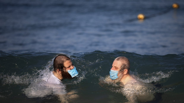 Ultra-orthodox Jewish men wearing protective face masks swim in the Mediterranean Sea on a beach segregated for males three days a week in Tel Aviv, Israel.