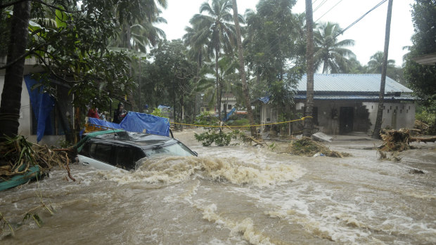 A car is submerged as roads and houses are engulfed in water following heavy rain and landslide in Kozhikode, Kerala state, India.