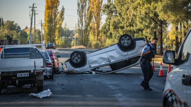 A car rests upside down in Mildura Street, Fyshwick, after crashing into three other vehicles.
