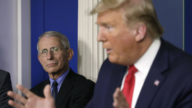 Anthony Fauci, left, listens as President Donald Trump speaks during a Coronavirus Task Force news conference.