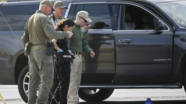 Law enforcement officials process a scene involved in Saturday's shooting.