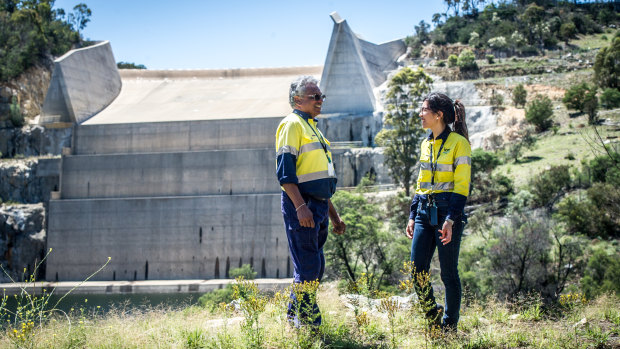 Icon Water water industry operator Siva Preeyadarshanan and operations process engineer Alice Liao discuss the Googong Dam water level in front of the dry spillway.