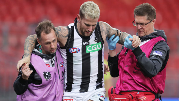 Jeremy Howe is aided off the field with a knee injury during round four. 