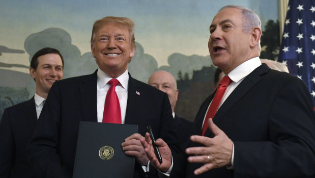 Donald Trump smiles as he holds a proclamation formally recognising Israel's sovereignty over the Golan Heights with Israeli Prime Minister Benjamin Netanyahu.