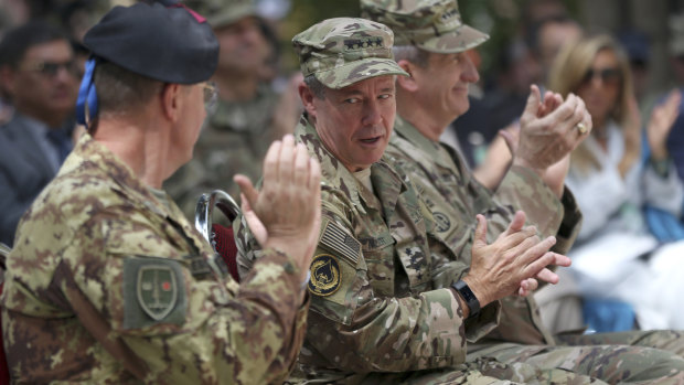 Incoming US Army General Austin Miller, second from left, talks to his colleague as outgoing US Army General John Nicholson, third from left, claps during the change of command ceremony at Resolute Support headquarters, in Kabul, Afghanistan, on Sunday.