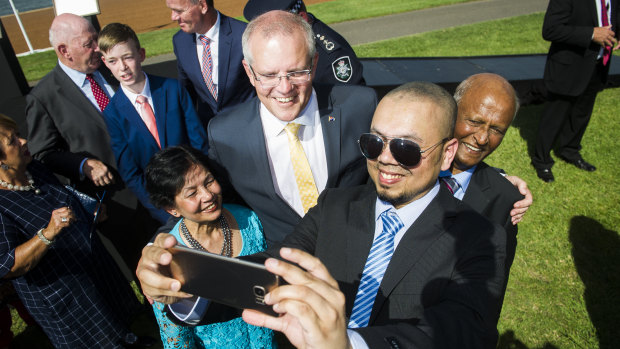 Prime Minister Scott Morrison takes a photo with new Australian citizens Farina Ahmed, Shahzad Ahmed and Iftikhar Ahmed on Saturday morning.