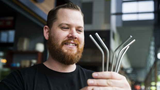 Tristan Morthorpe holding the steel straws at the Atlas cafe in Gungahlin.