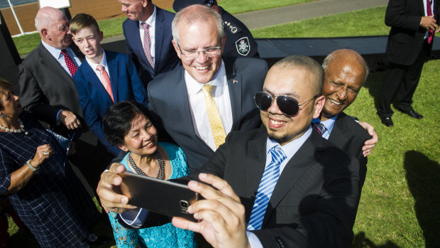Prime Minister Scott Morrison takes a photo with new Australian citizens Farina Ahmed, Shahzad Ahmed and Iftikhar Ahmed on Saturday morning.