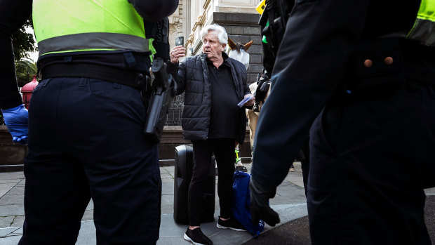 Police question members of the public not wearing a mask in Melbourne's CBD.