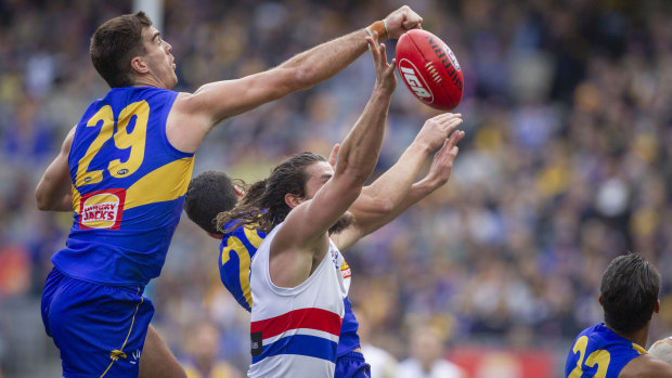Hit and miss: West Coast's Scott Lycett attempts a clearance over Bulldog Tom Boyd.