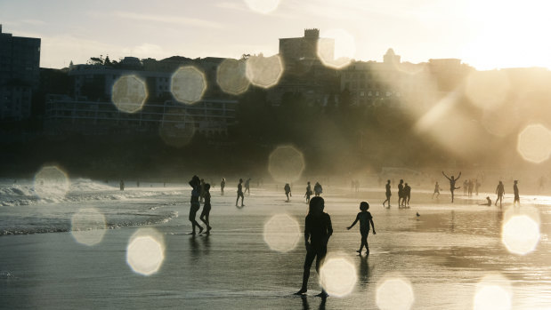 Bathers at Bondi Beach as the sun sets.