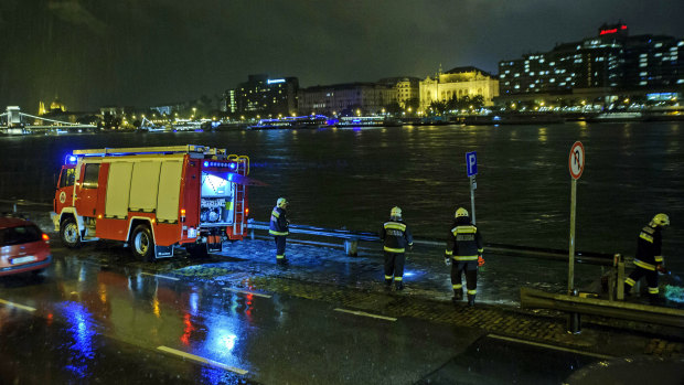 Rescuers search for victims on the river bank early on Thursday.