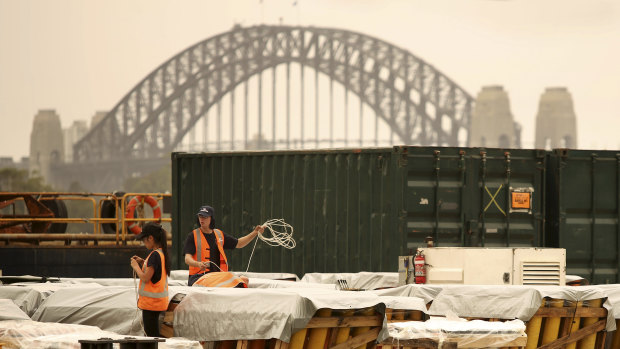 Pyrotechnicians survey Sydney's New Year's Eve fireworks under smoke haze on Monday. 