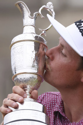 Cameron Smith kisses the claret jug trophy as he poses for photographers on the 18th green after winning the British Open at St Andrews.