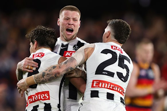 Jordan De Goey celebrates a goal with Lachie Schultz and Jack Crisp.