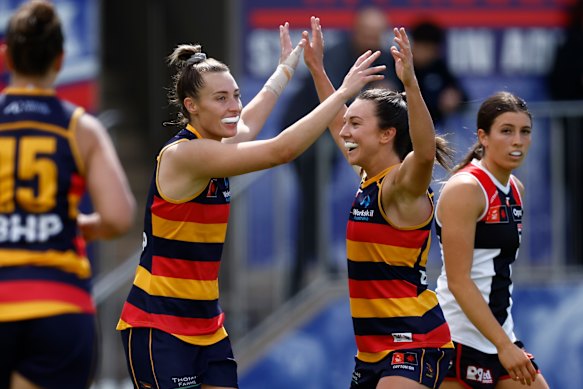 Caitlin Gould and Niamh Kelly of the Crows (right) celebrate a goal in their elimination final win.