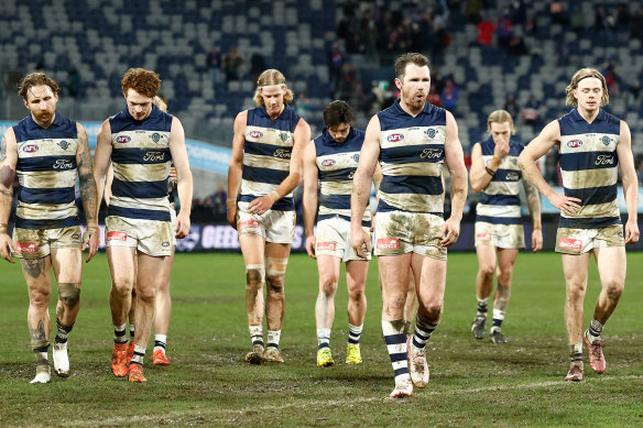 Muddied and beaten, the Cats trudge off GMHBA Stadium after another home loss.