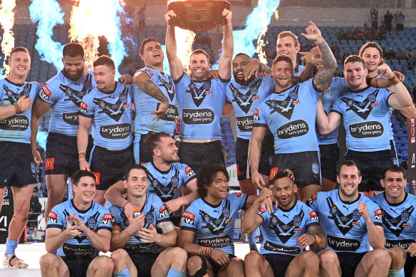 James Tedesco of the Blues holds aloft the Origin trophy after game three on the Gold Coast.