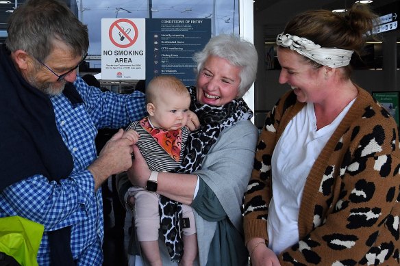 Peter Zwart (left) and his wife Anne  (3rd from left) from Christchurch meet their granddaughter Maggie Johnson, five months, and daughter Joanna Zwart (right) at the Sydney International Airport arrivals terminal.
