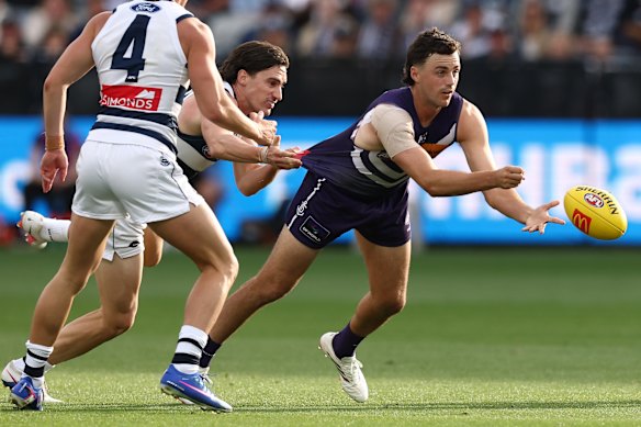 Jordan Clark of the Dockers handpasses the ball.