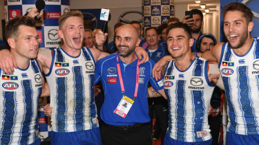 Interim coach Rhyce Shaw sings the songs with his victorious players after the Kangaroos' win over Richmond.