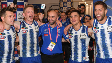 Interim coach Rhyce Shaw sings the songs with his victorious players after the Kangaroos' win over Richmond.