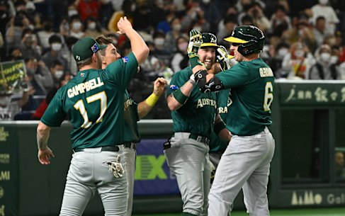 Robbie Glendinning celebrates with teammates after hitting a three-run home run to make it 5-4.