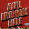 Fans of Liverpool, wearing scarfs featuring Diogo Jota and carrying balloons which spell out “20” make their way to the stadium as a mural which reads “You’ll Never Walk Alone” can be seen as tributes are laid for Diogo Jota at Anfield on July 03, 2025 in Liverpool, England. The current Liverpool player and Portugal international Jota died in a car crash in Zamora, Spain at the age of 28