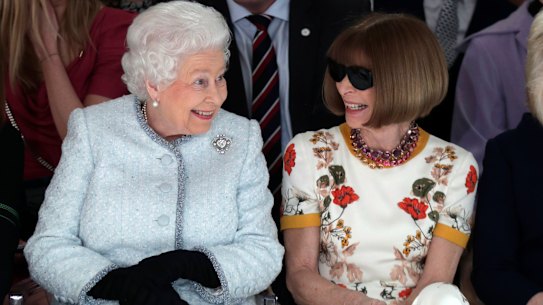 Wintour views a runway show with Queen Elizabeth in London in 2018.