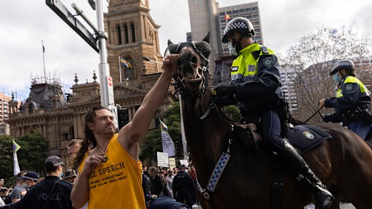 A man punches a police horse during an anti-lockdown rally in Sydney’s CBD.