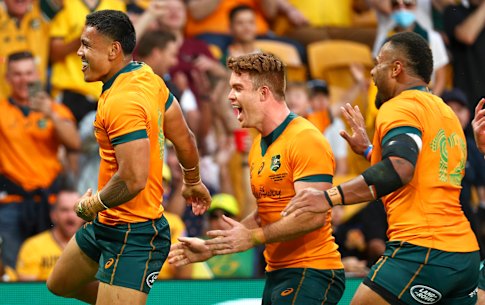 Australia’s Len Ikitau, left, is congratulated by teammates after scoring his first Test try.