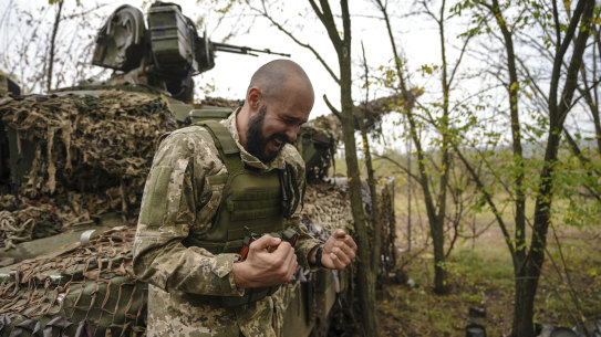 A Ukrainian soldier speaks to his brothers in arms while his unit waits for order to fire in Bakhmut, Ukraine, Sunday.