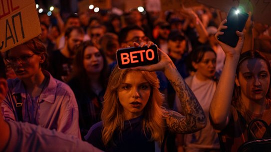 A woman holds a phone with a sign that reads “Veto” during the protest in central Kyiv on Tuesday against the law aimed at regulations of anti-corruption institutions.