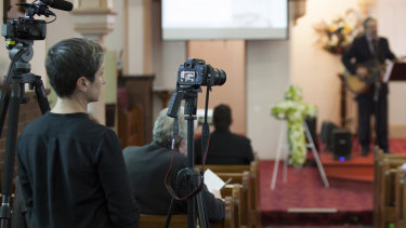 Michelle Bova films a funeral service for Funeral Video Australia. 