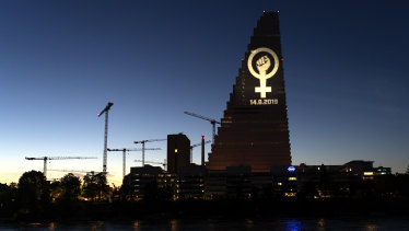 The women's strike logo is projected on the Roche Tower ahead of a nationwide women's strike.