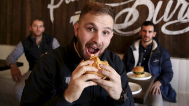 Vegan Josh Berki bites into a meat-free, plant based, hamburger at Soul Burger in Randwick.