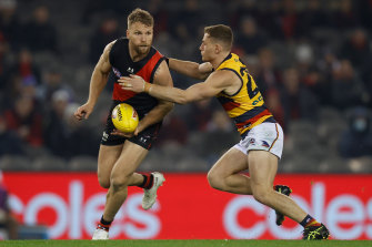 Essendon’s Jake Stringer looks to get the ball away as he is tackled by Rory Laird of the Crows.