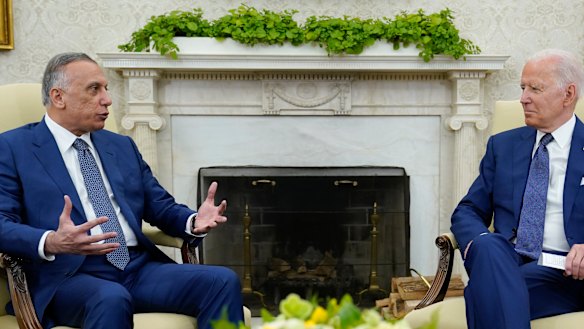 US President Joe Biden, right, listens as Iraqi Prime Minister Mustafa al-Kadhimi speaks during their meeting in the Oval Office.